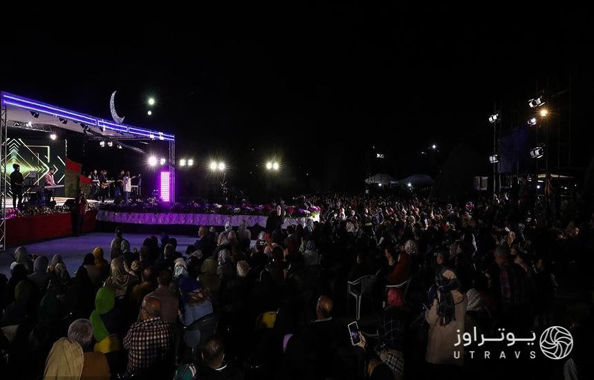 شب ماه رمضان در پارک لاله تهران و جمعیت زیادی از مردم که جلوی یک سن در فضای باز پارک ایستاده‌اند. 